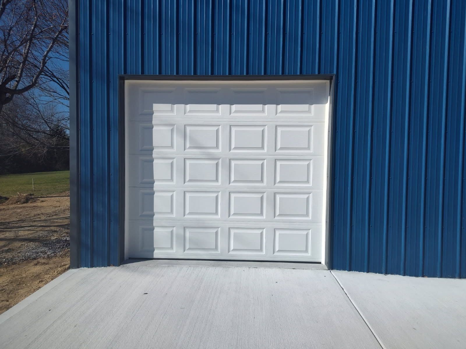 Classic White Garage Door Installation in Newly Built Shop image